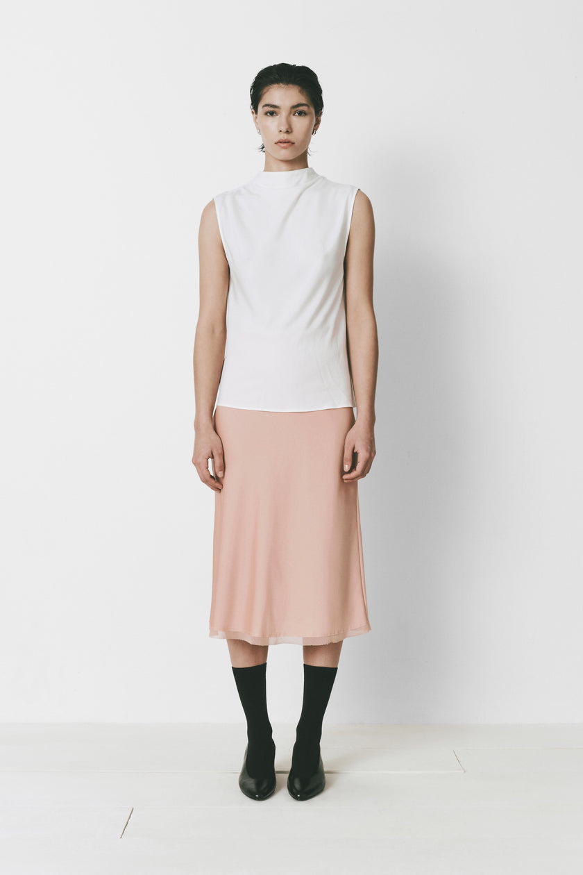 Rue Sophie Loire Top in white, high neck, paired with peach skirt and black socks