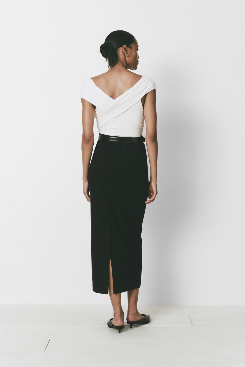 Louise Bodysuit in white wrap top with black high-waisted skirt, showcasing the wrap detail.