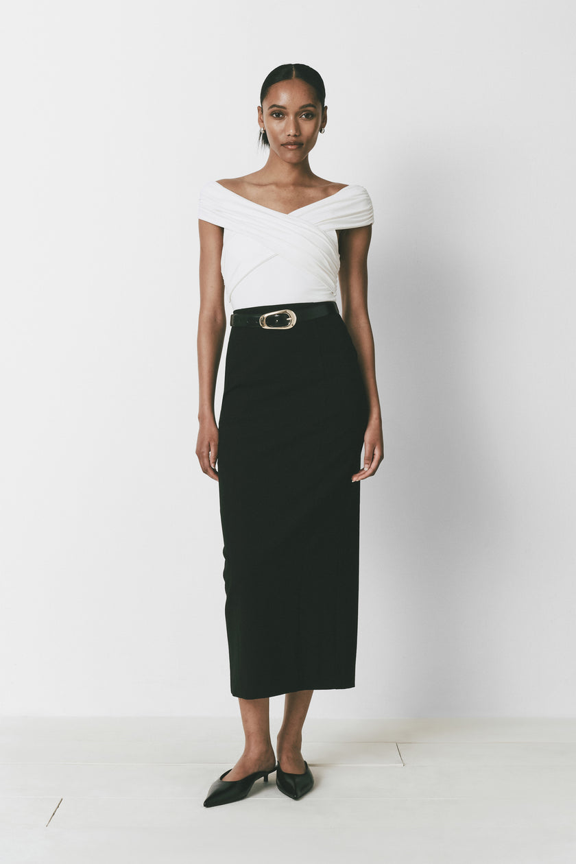 Louise bodysuit, white wrap top with black high-waisted skirt and black belt