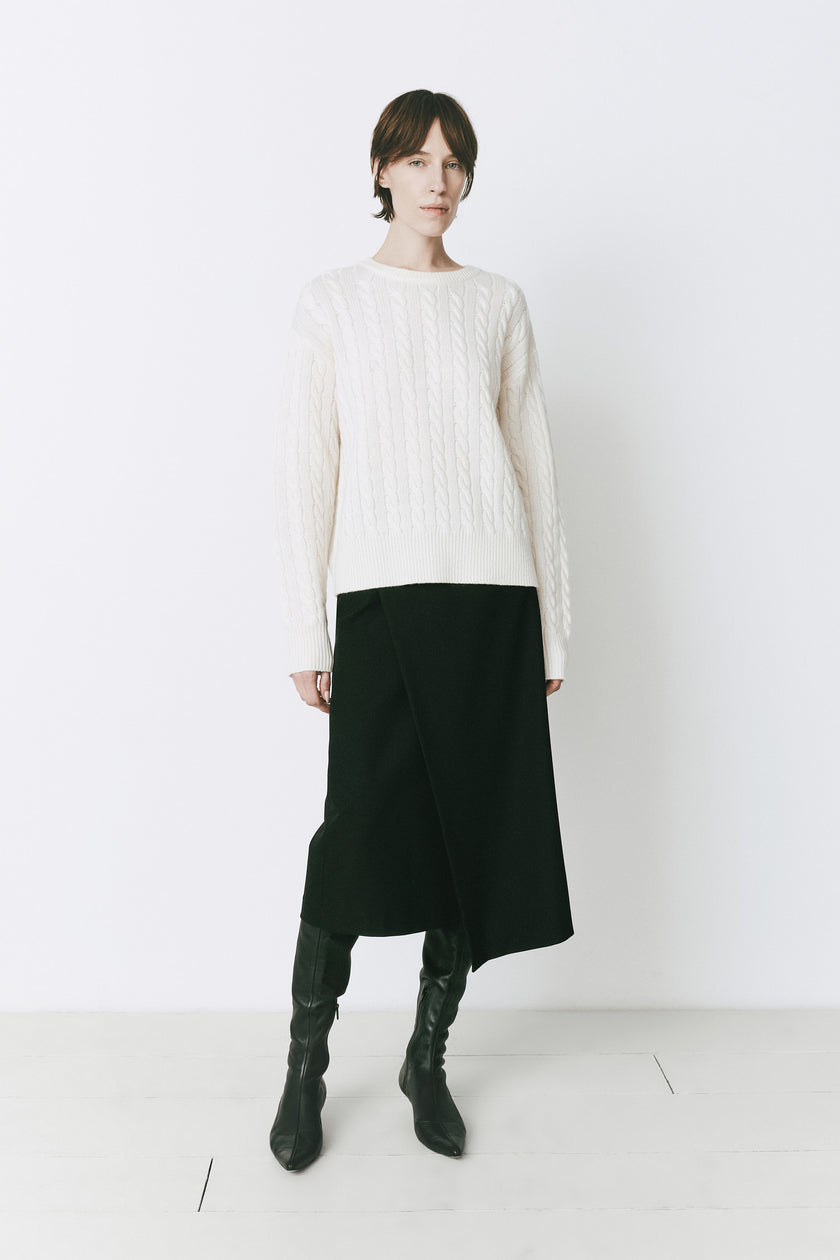 Ivory wool-cashmere cable knit sweater with black skirt and boots. Perfect for layering.