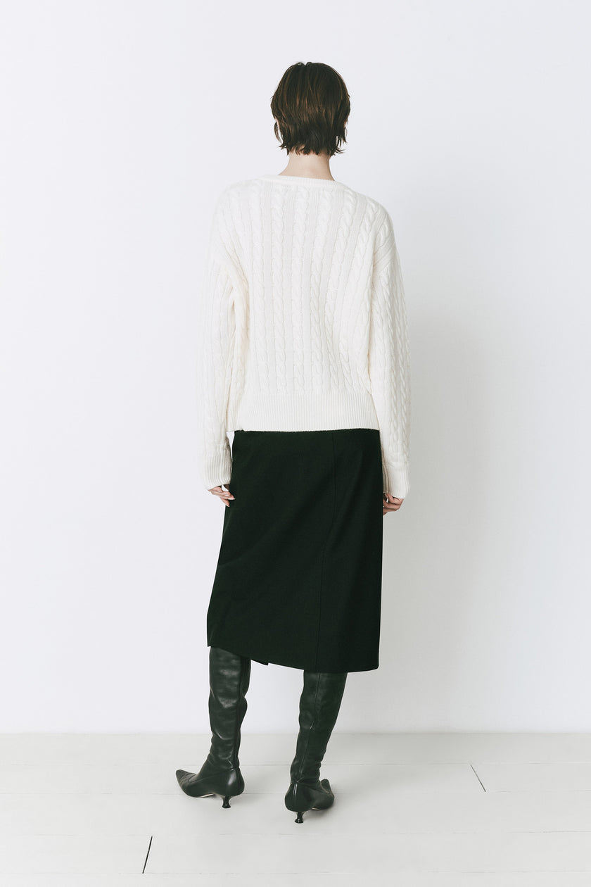 Ivory cable knit sweater with a black skirt and black leather boots. Rue Sophie Lyon Sweater outfit.