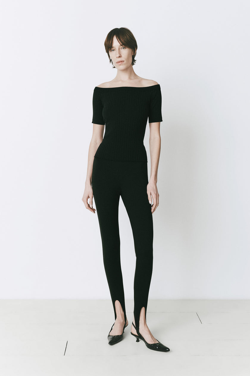 Black off-shoulder viscose-nylon top and leggings. Modern, minimalist style, perfect for evening wear.