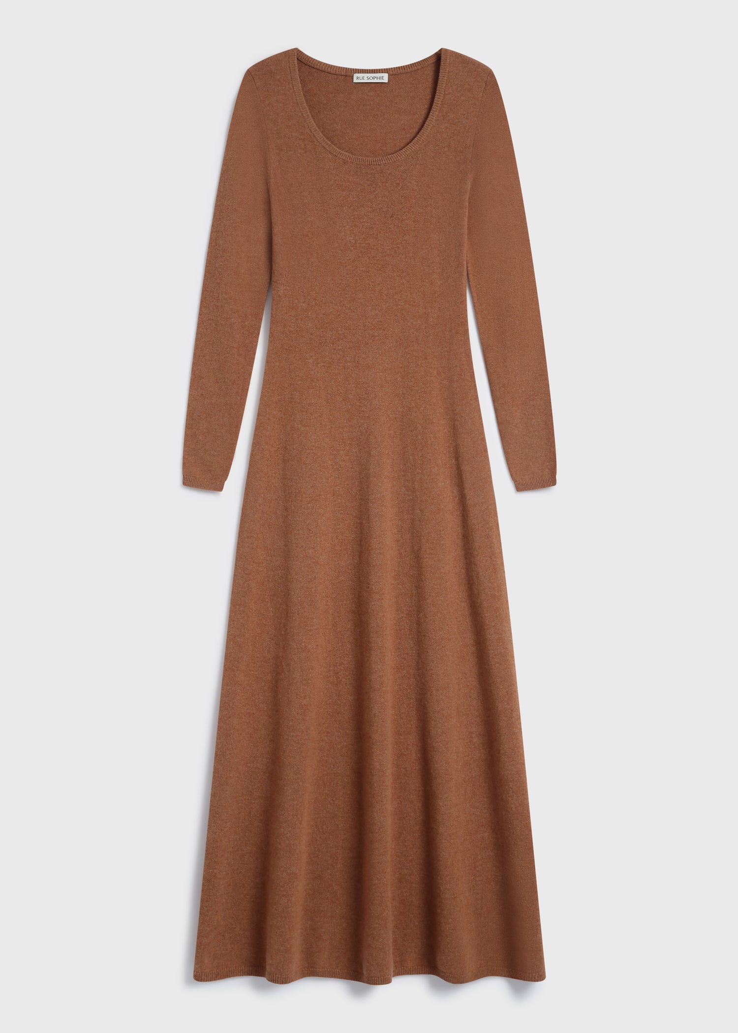 Model wearing the Mignet Sweater Dress, a long, oversized brown knit dress with a round neck and long sleeves