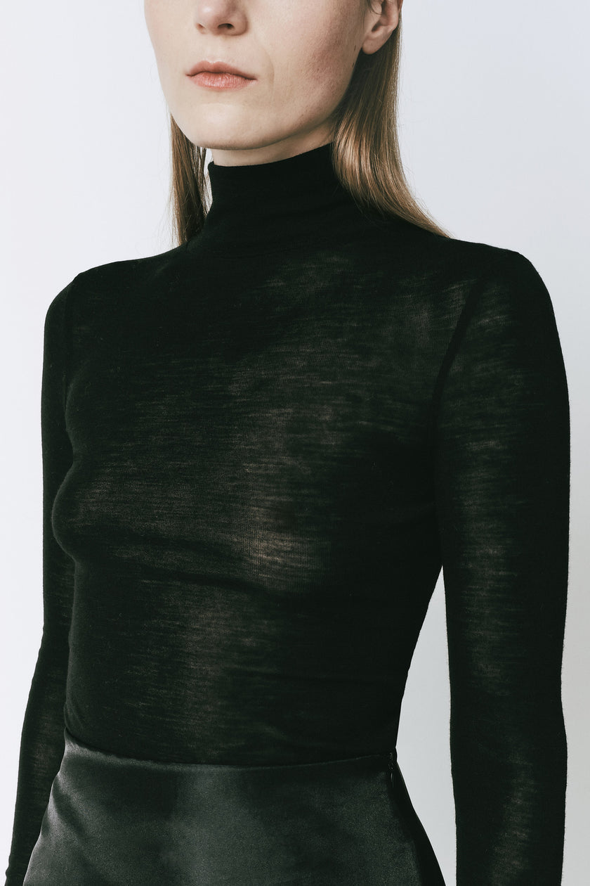 Black Panthéon turtleneck top in merino wool, perfect for a sophisticated look.