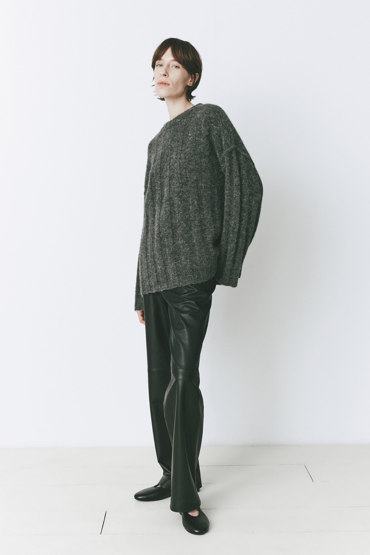 Model wearing an oversized sweater with a round neck, dropped shoulders, and wide sleeves, in soft luxury knitwear