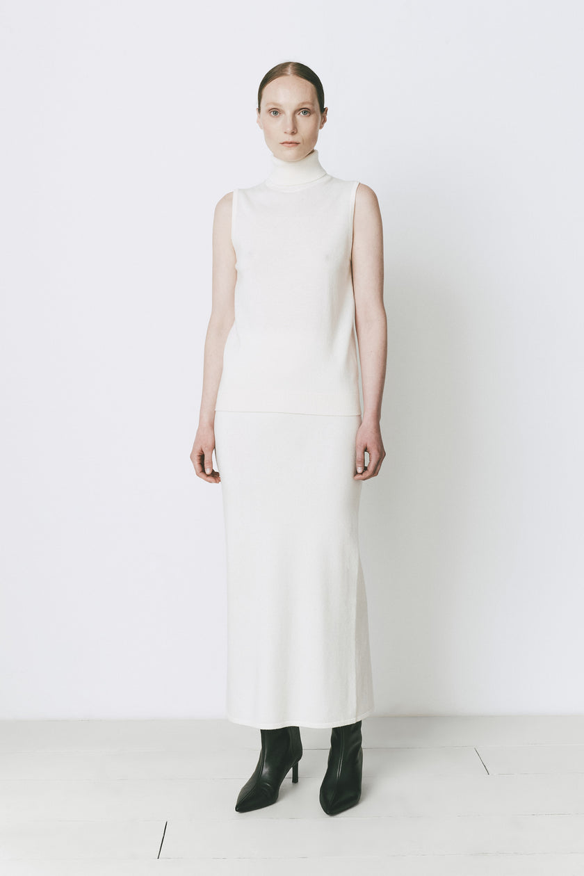 Woman in Rue Sophie white wool-cashmere blend sweater and midi skirt