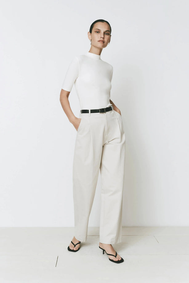 Cream wide-leg Parc Pant, paired with a white top, black belt, and sandals. Tailored for a refined look.