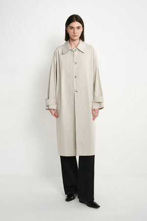 A model wearing the Rue Sophie Roche Oversized Jacket in cement with a pointed collar, button-front closure, adjustable cuff tabs, and an oversized straight silhouette, front view.