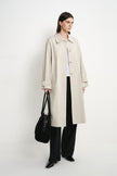 A model wearing the Rue Sophie Roche Oversized Jacket in cement, featuring a relaxed oversized fit, pointed collar, button-front closure, and side pockets, three-quarter front view.