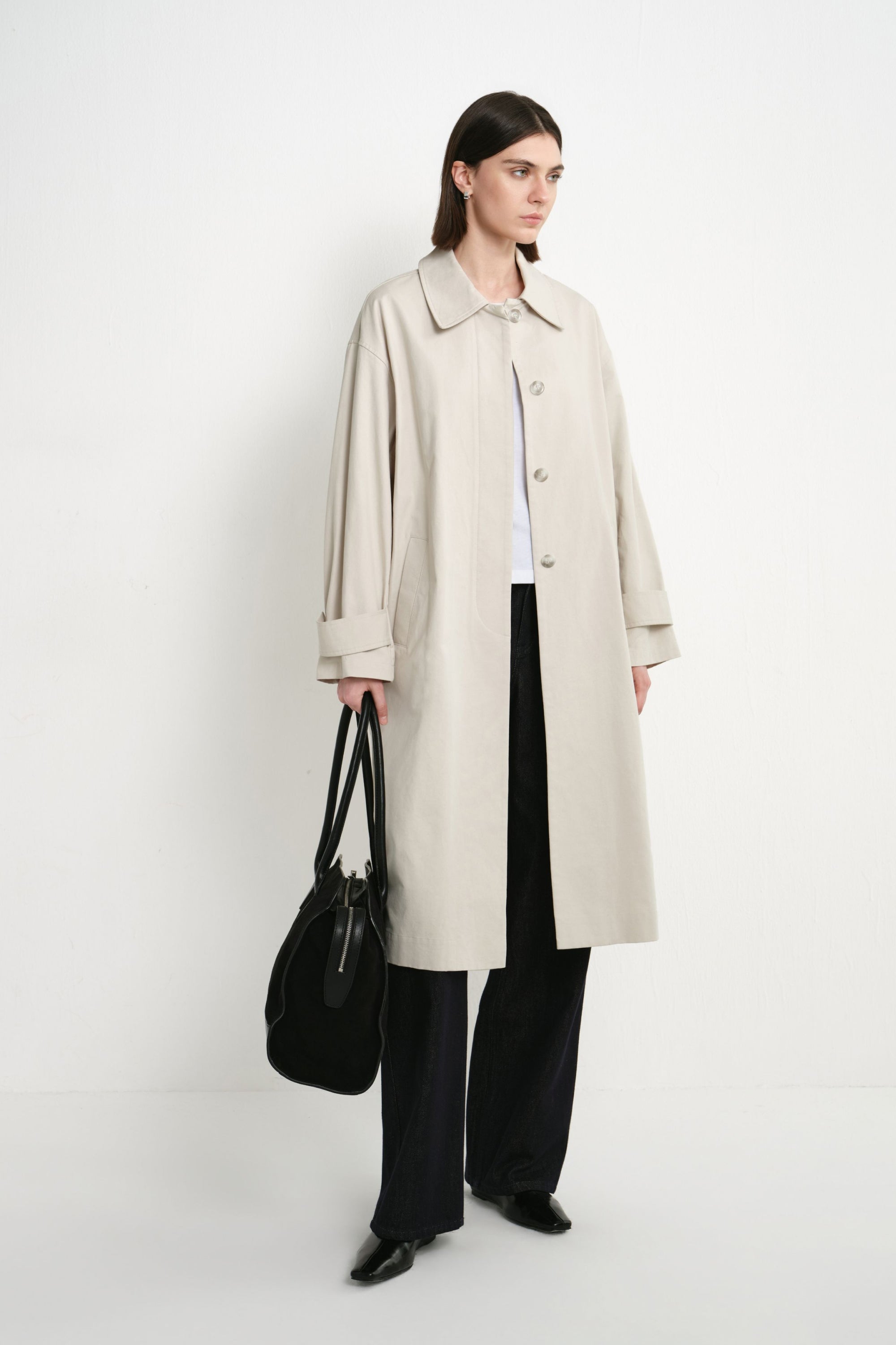 A model wearing the Rue Sophie Roche Oversized Jacket in cement, featuring a relaxed oversized fit, pointed collar, button-front closure, and side pockets, three-quarter front view.