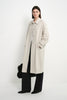 A model wearing the Rue Sophie Roche Oversized Jacket in cement, featuring a pointed collar, button-front closure, dropped shoulders, and a relaxed long silhouette, three-quarter front view.