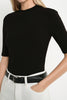 A model wearing the Rue Sophie Chabot Mock Neck Top in black, featuring a fitted silhouette, mock neckline, and elbow-length sleeves, front view.
