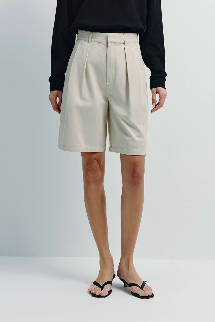 Light beige Darrion Bermuda Shorts. Model wearing black top and sandals, tailored fit, cotton-lyocell blend.