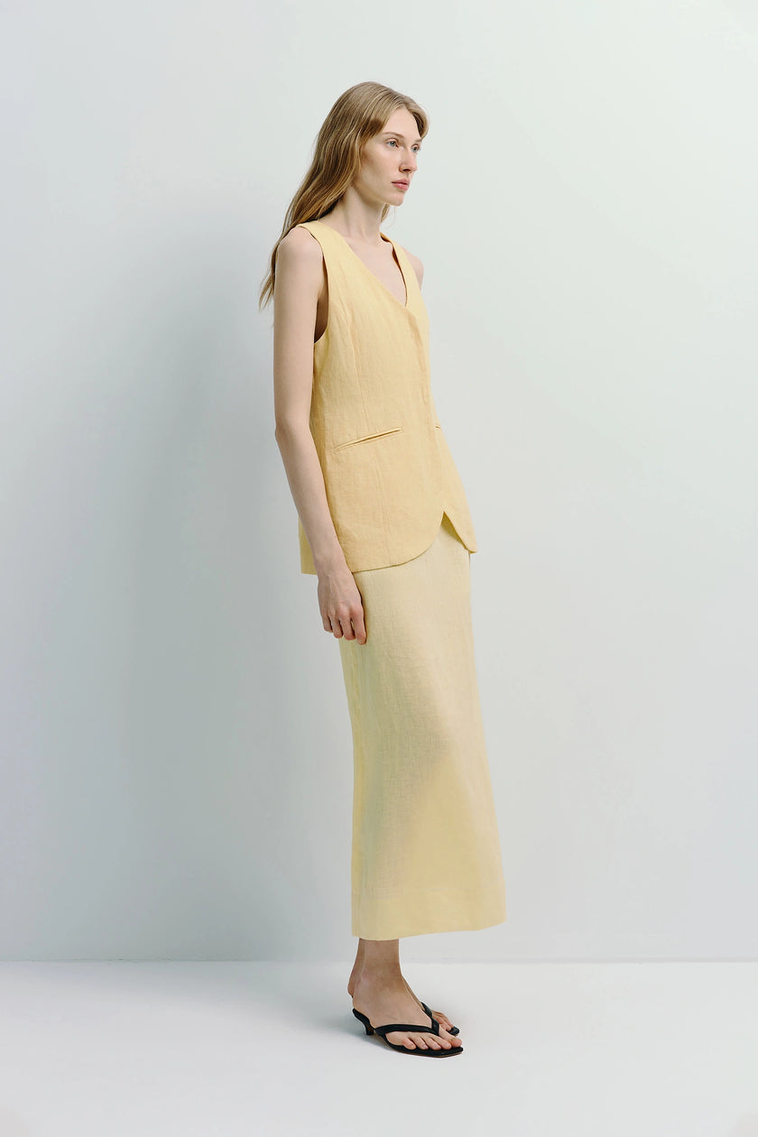 Woman in light yellow linen Adan Midi Skirt and matching vest