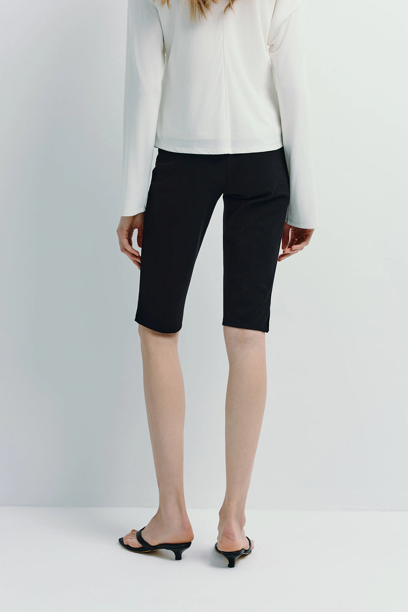 Black Sadie Shorts, rayon spandex blend bermuda shorts, with a white top, back view