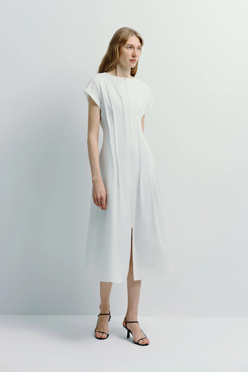 White Verri Pintuck Midi Dress with pintuck details, styled with black heels. 100% cotton, flowy design.