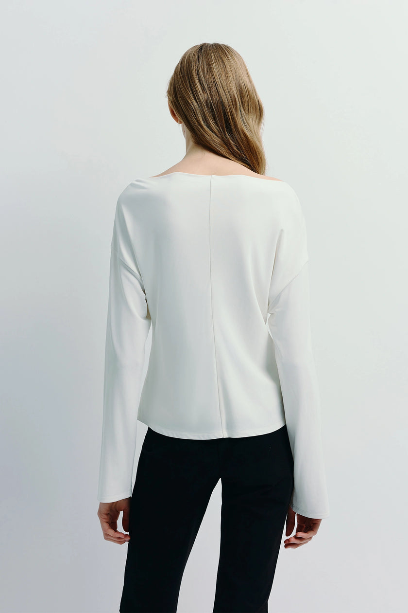 White Laure Top with slit sleeves, paired with black pants, minimalist chic design