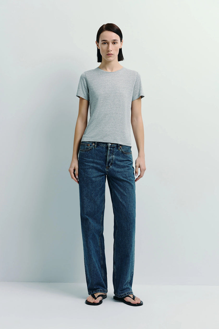 Heather grey crew neck tee made with sustainable cotton paired with denim jeans.