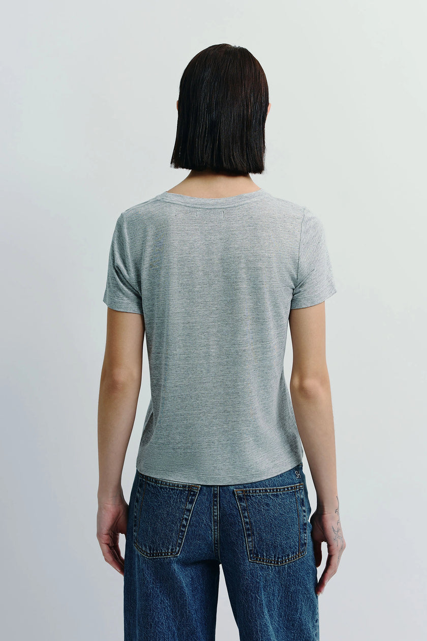 Heather grey crew neck tee made of sustainable cotton on a person, paired with denim jeans. Effortless everyday wear.