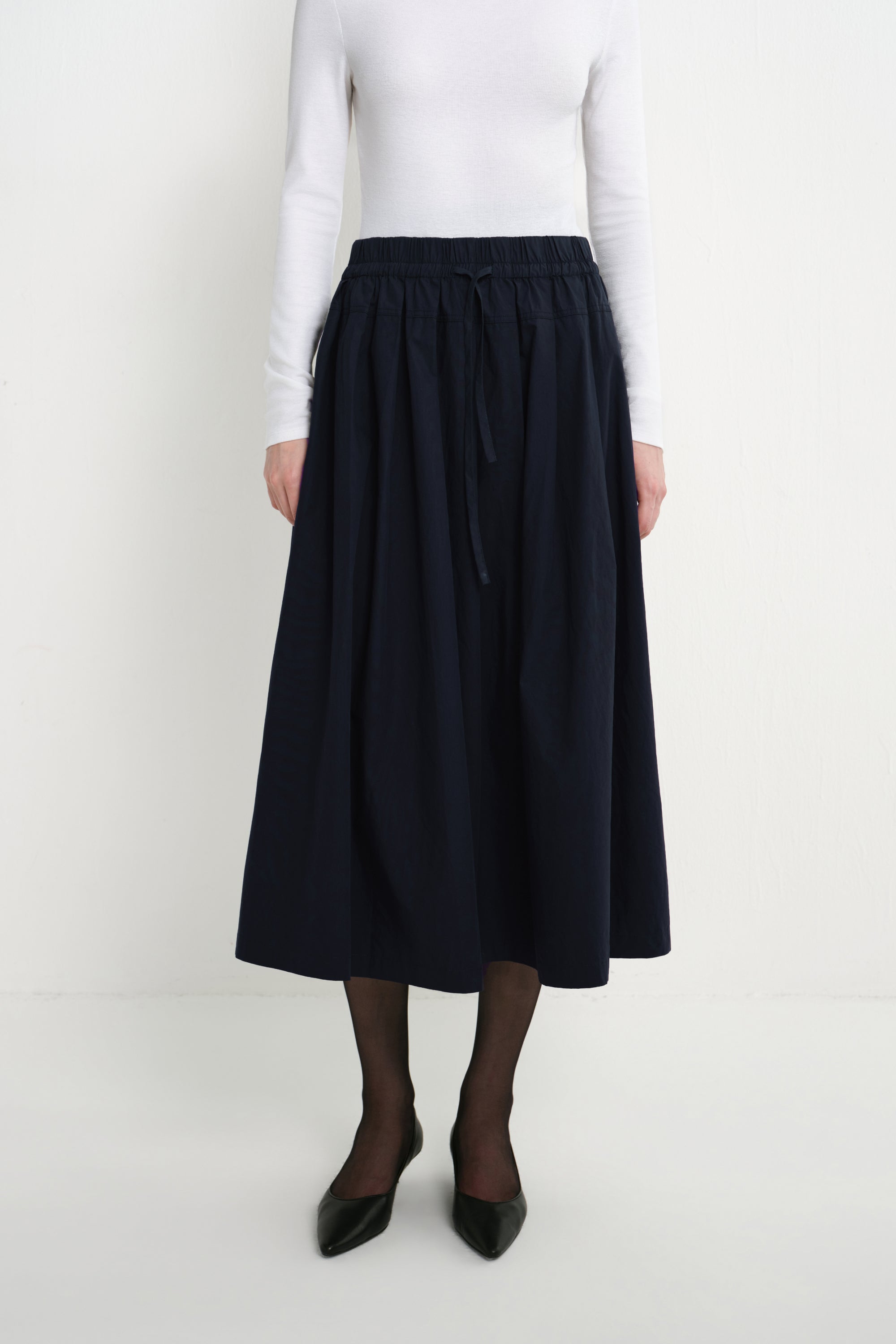Front close-up of the Rue Sophie Panier Drawstring Waist Pleated Skirt in Navy, highlighting the drawstring waistband and softly gathered volume.