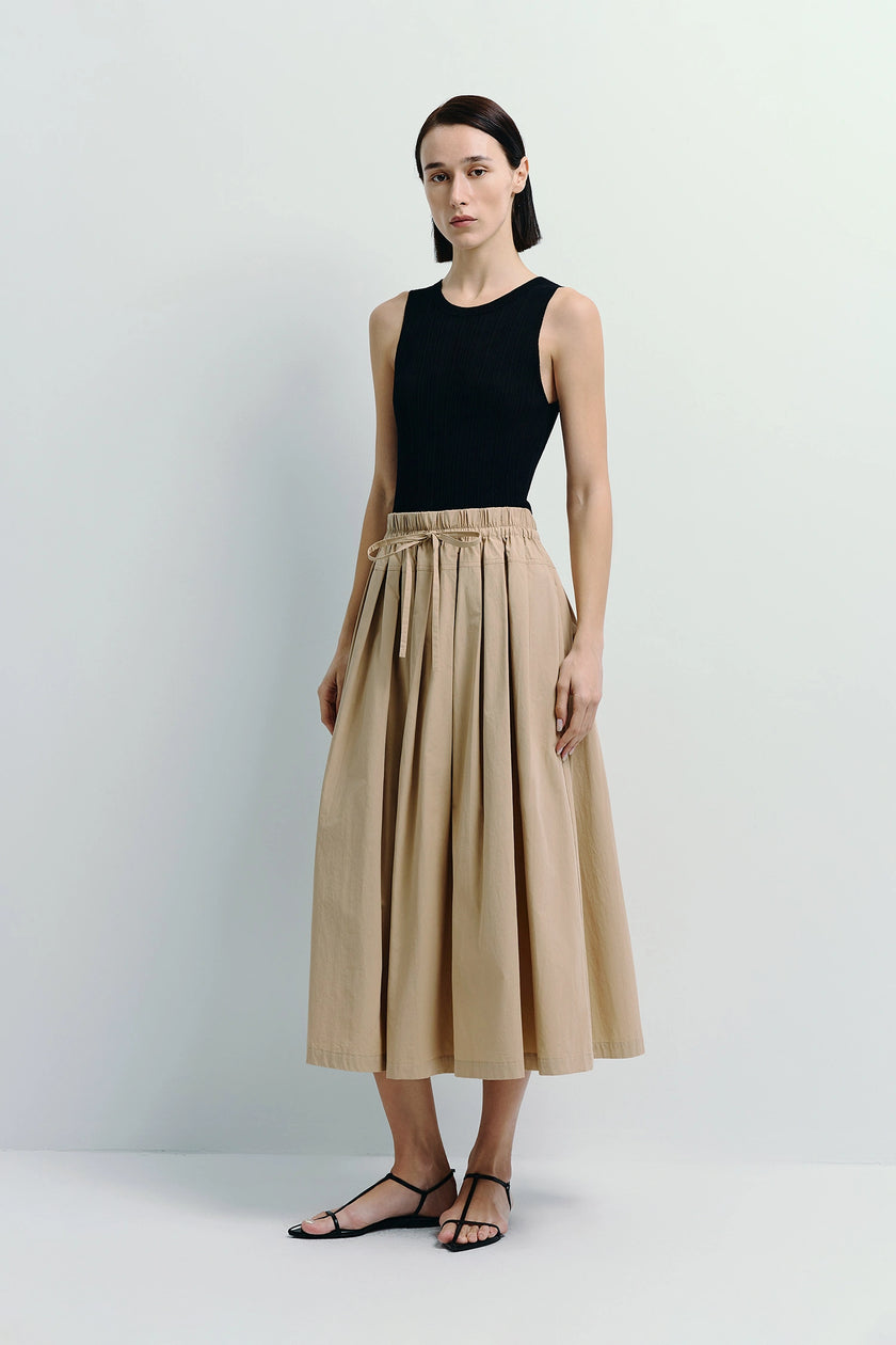 Rue Sophie Panier Drawstring Waist Pleated Skirt in beige cotton, black top, on model