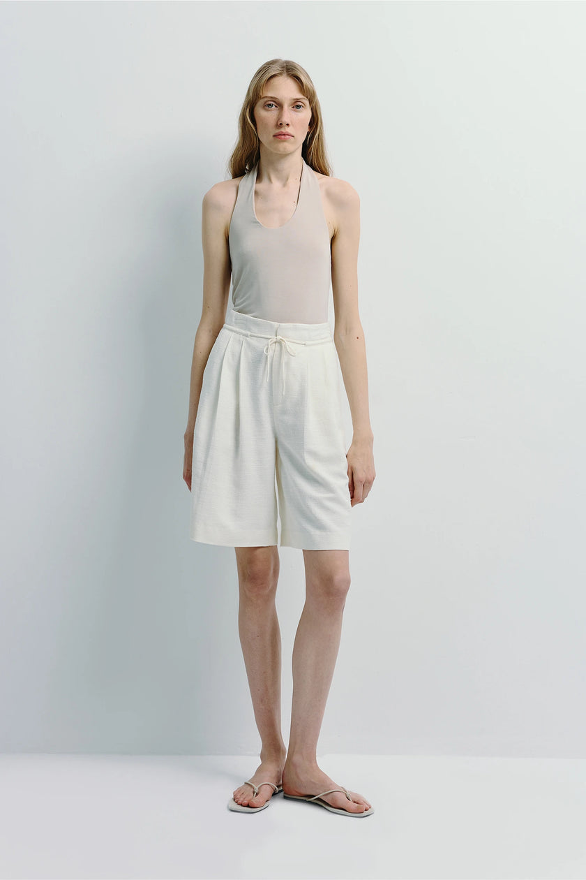 Beige Chaleur Halter Top and white shorts, streamlined silhouette, soft drape, paired with sandals