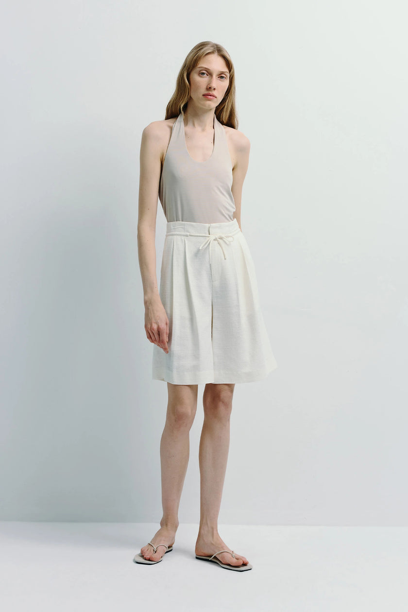 White linen blend Arc Tie Waist Short with adjustable tie waist, paired with a beige halter top