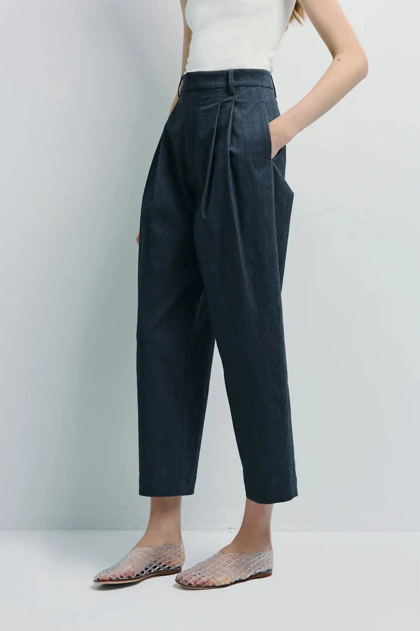 Campagne Pleated Tapered Pant in soft cotton twill. High-waisted trousers with tapered leg, model wearing with white top.