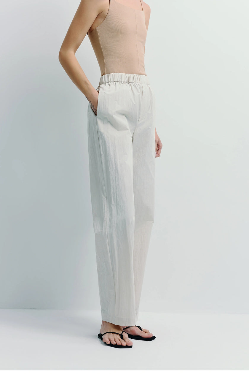 Light grey crinkled cotton pants with elastic waistband, modern essential for relaxed wear.