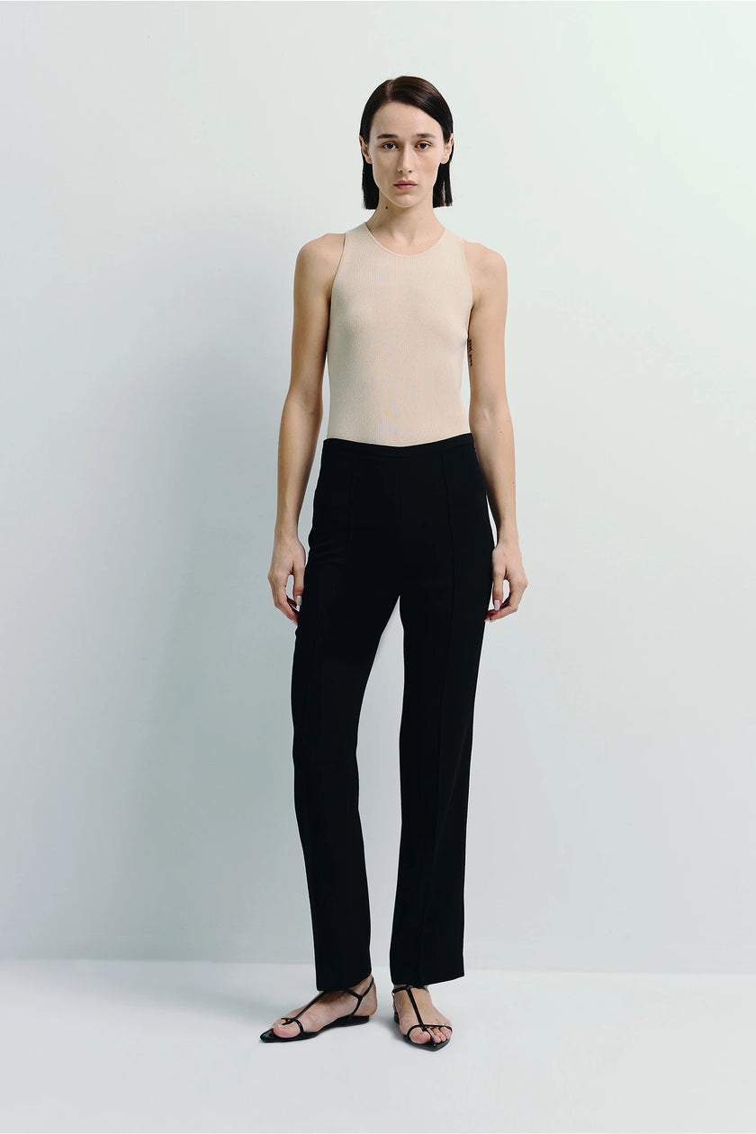 Black Coupe Tapered Leg Slim Pant in black, paired with a neutral top, showcasing the tailored fit and slim leg