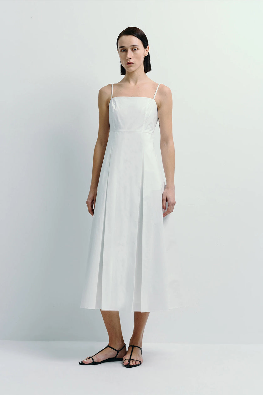 Nantes Cami Dress in white cotton with pleat detail. Minimalist design, spaghetti straps, elegant.