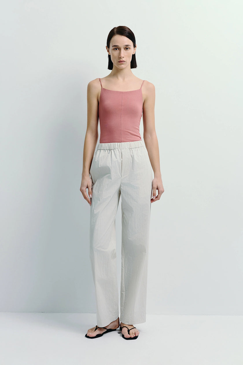 Modern essential crinkled cotton pants in cream, paired with a pink top. Perfect for relaxed wear.
