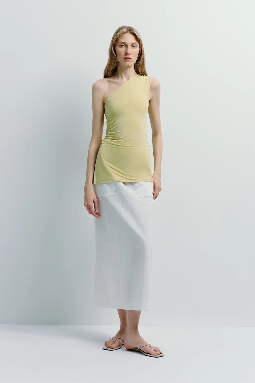 Clément One Shoulder Top in pale yellow-green with white skirt. Modern and elegant look.