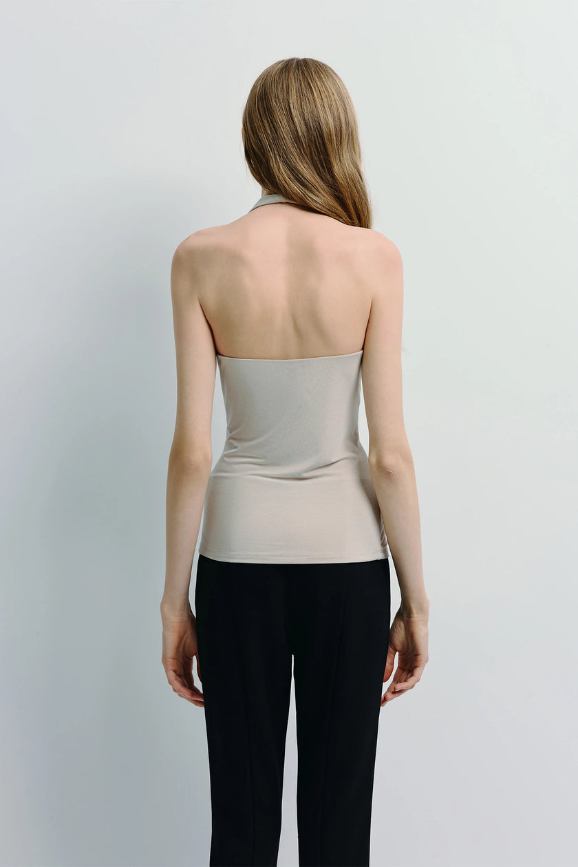 Chaleur Halter Top in beige, streamlined silhouette, soft drape, paired with black pants.
