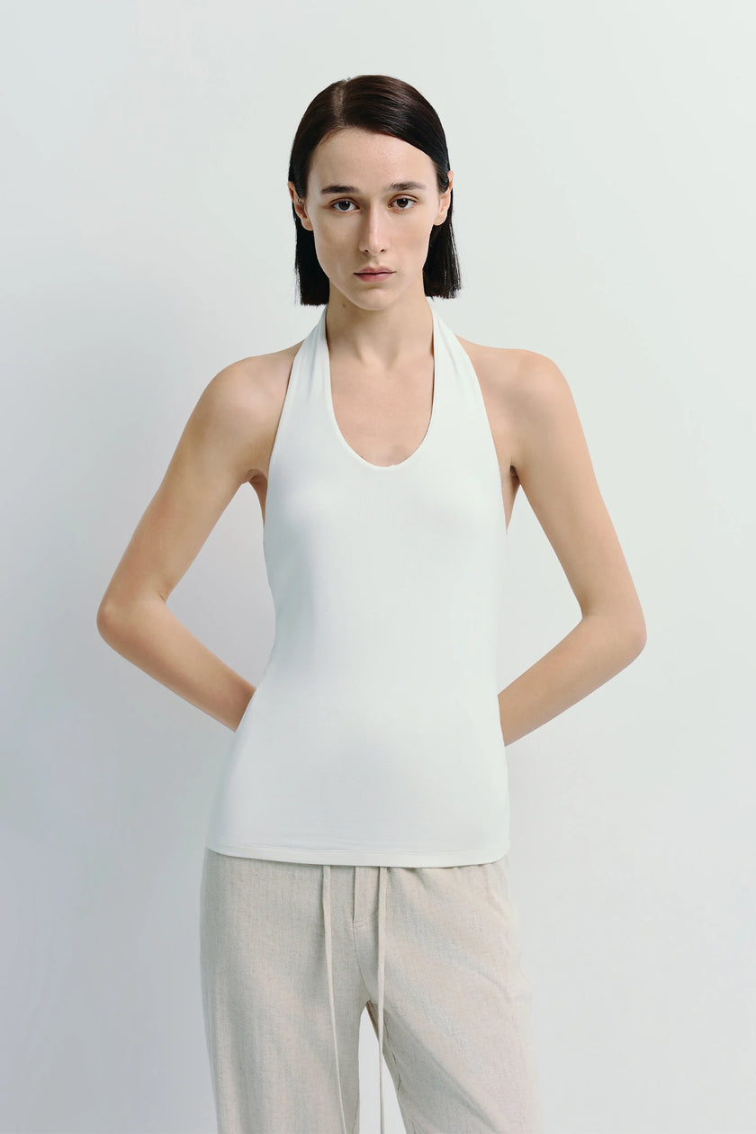 Chaleur Halter Top in white with minimalist design, paired with beige linen pants. Soft, breathable modal blend.