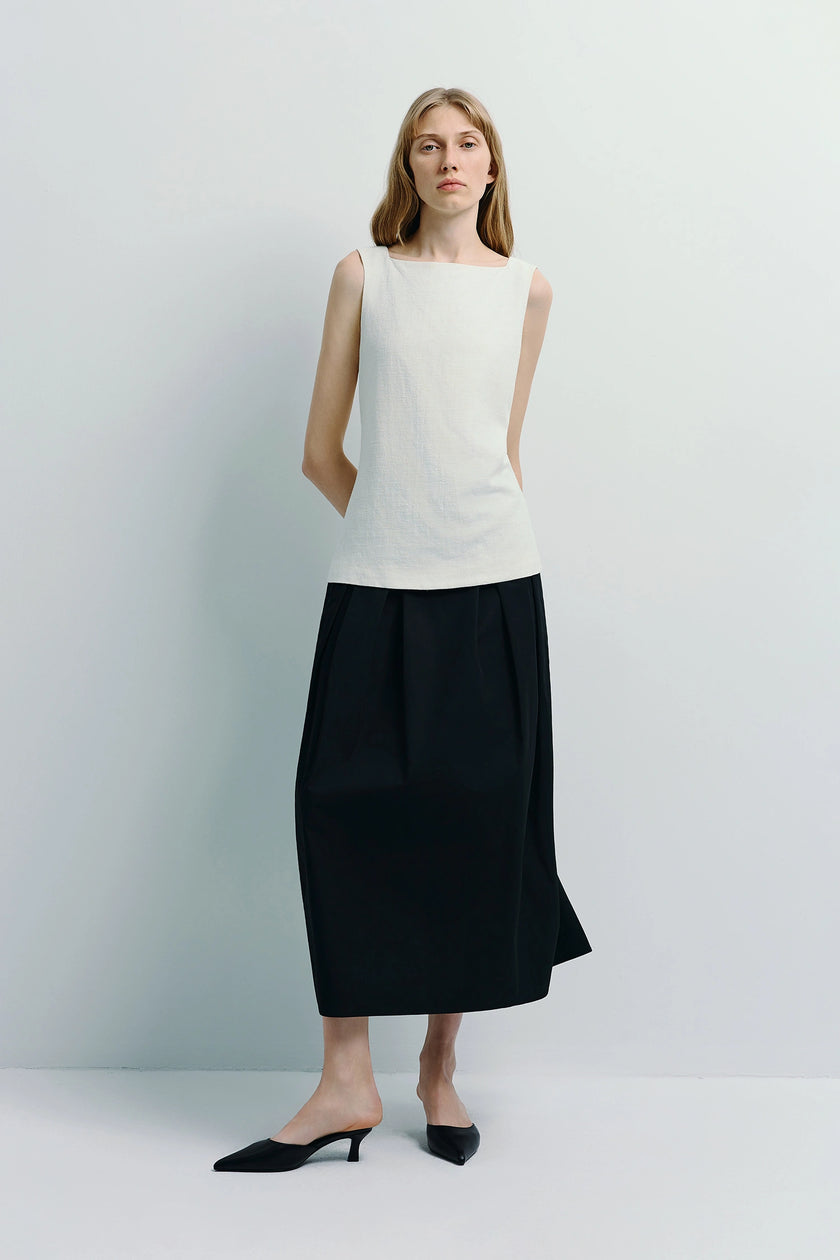 Woman wearing Carré High Square Neck Top, a white linen-cotton blend top and black skirt