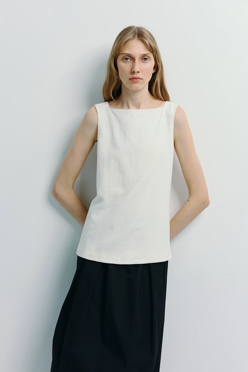 Woman in white linen Carré High Square Neck Top and black skirt
