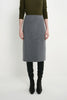 A model wearing a gray wool-blend pencil skirt, styled with an olive green long-sleeve top, black leggings, and black ankle boots, photographed against a light gray studio background.