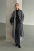 A model wearing the Rue Sophie Martine Belted Coat in grey with an oversized longline shape, wide lapels, button-front closure, and relaxed sleeves, three-quarter front view.