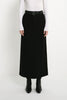 A model wearing the Rue Sophie Camberly Midi Skirt in black with a high waist, belt loops, center-front seam, and long structured silhouette, front view.