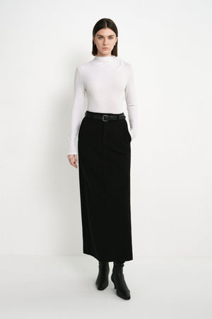 A model wearing the Rue Sophie Camberly Midi Skirt in black, featuring a high waist, clean center-front seam, and streamlined A-line silhouette, full-length front view.