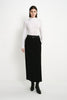 A model wearing the Rue Sophie Camberly Midi Skirt in black, featuring a high waist, clean center-front seam, and streamlined A-line silhouette, full-length front view.