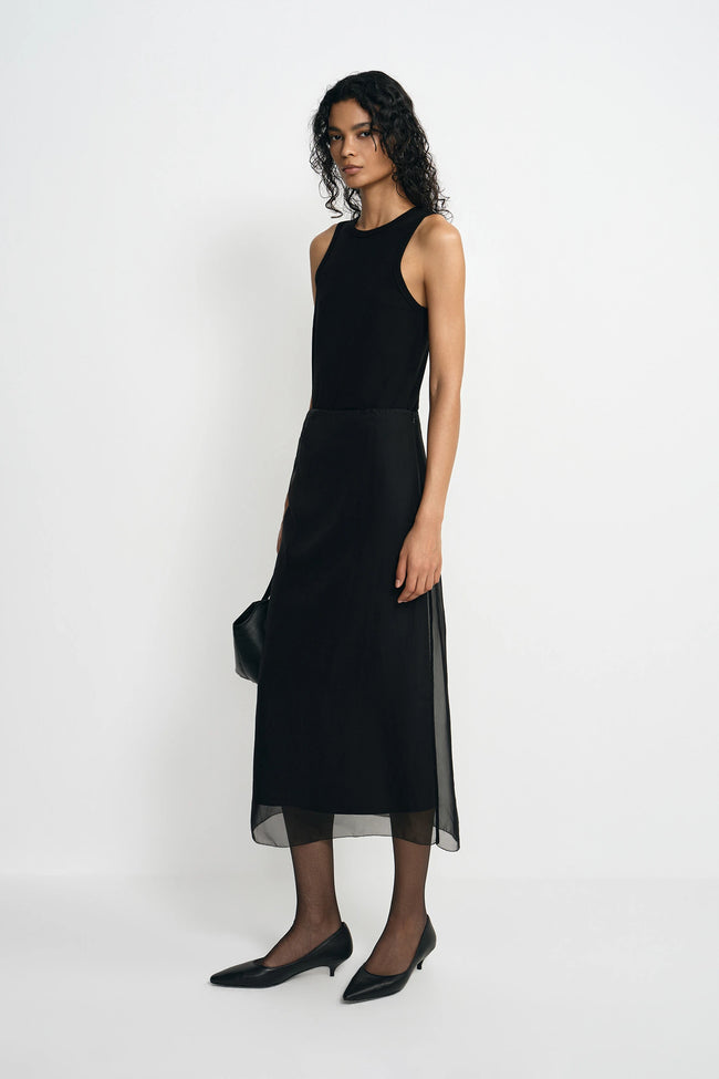 Woman wearing a black sleeveless dress on a white background