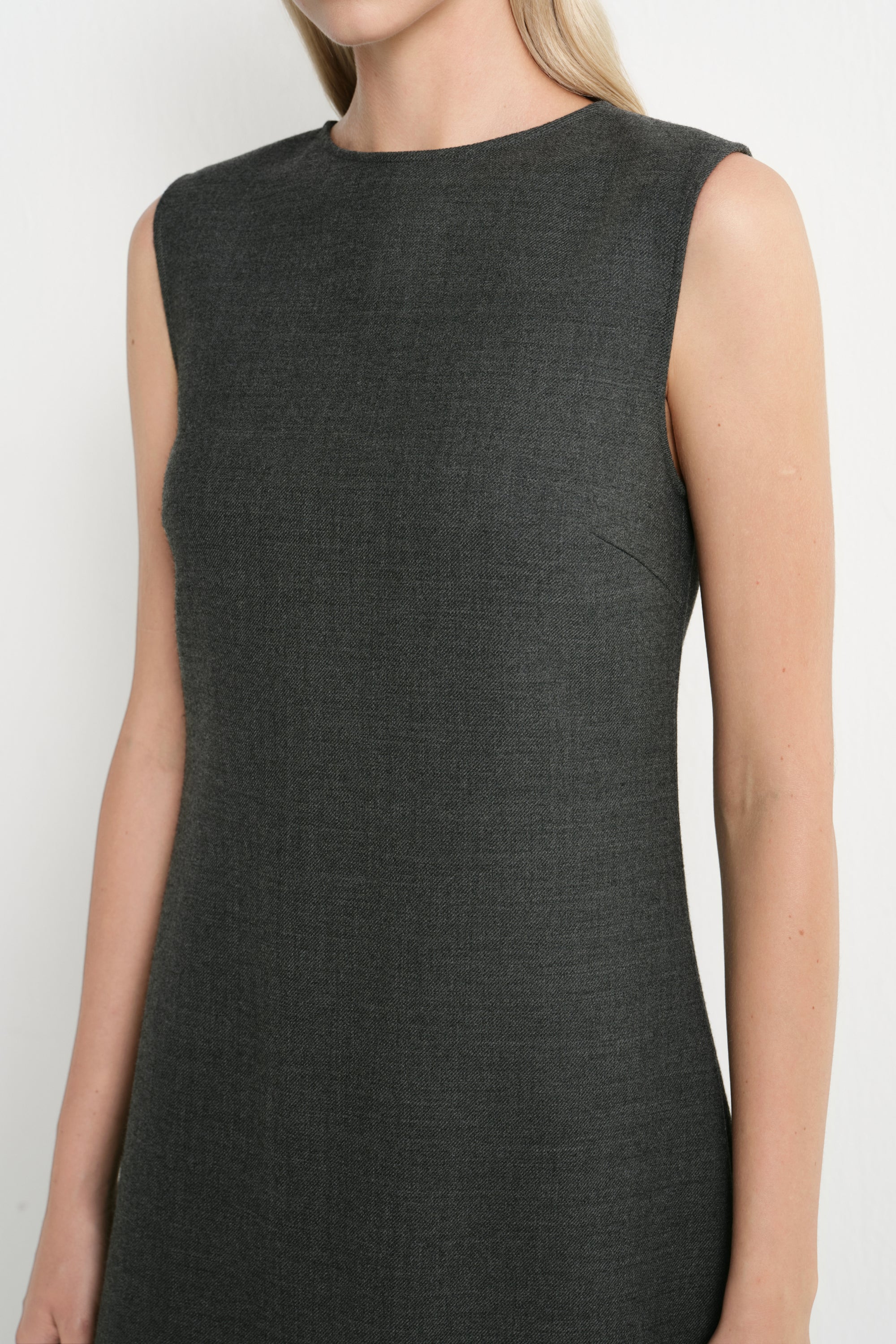 A sleeveless dark charcoal gray knit dress with a crew neckline, shown on a model against a plain light background.