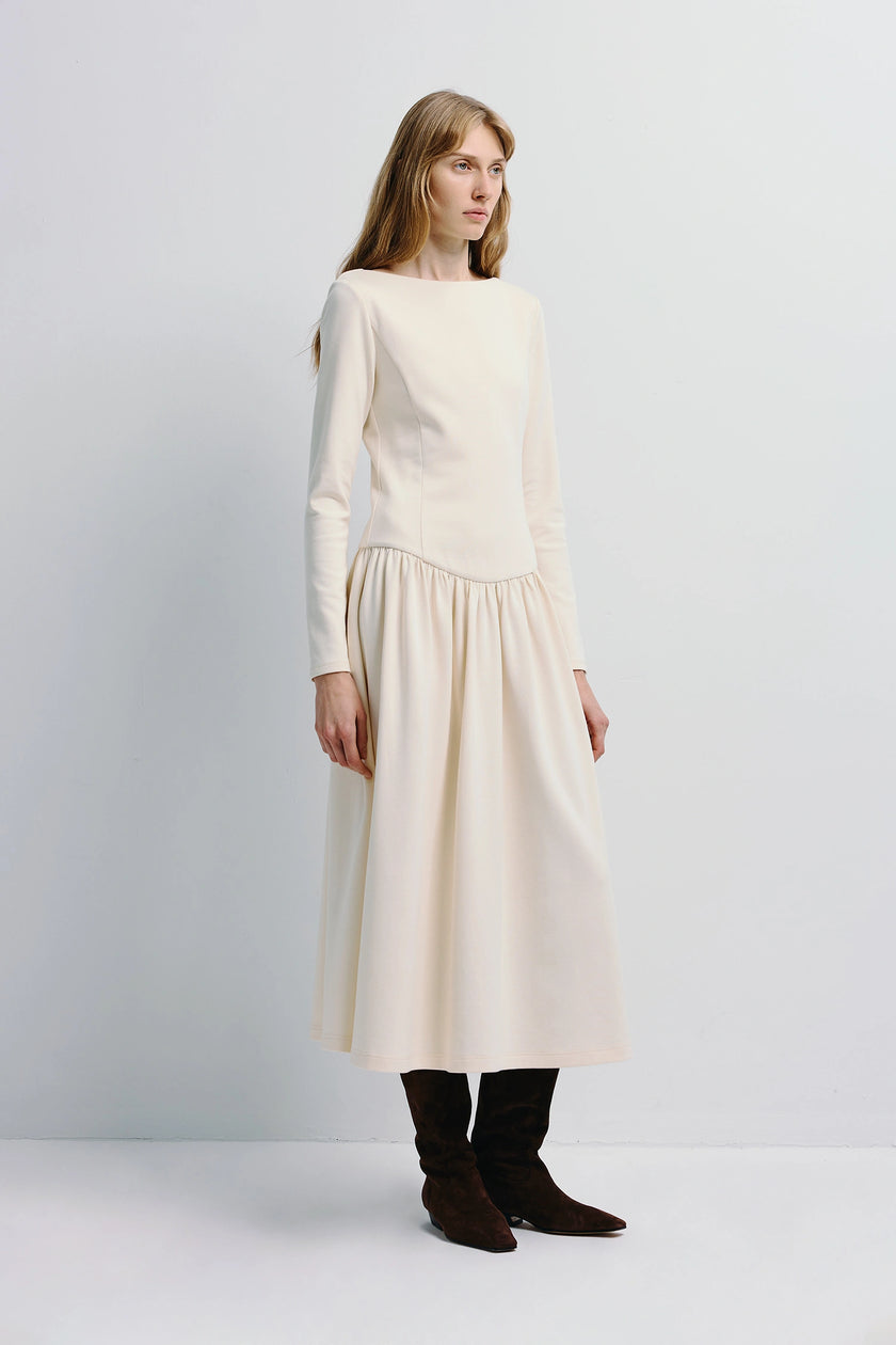 Lisette Boatneck Midi Dress in cream, long sleeves, and brown boots; understated elegance.