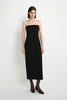 A model wearing the Rue Sophie Webster Tube Dress in black, featuring a strapless straight neckline, fitted column silhouette, and clean mid-calf length, front view.