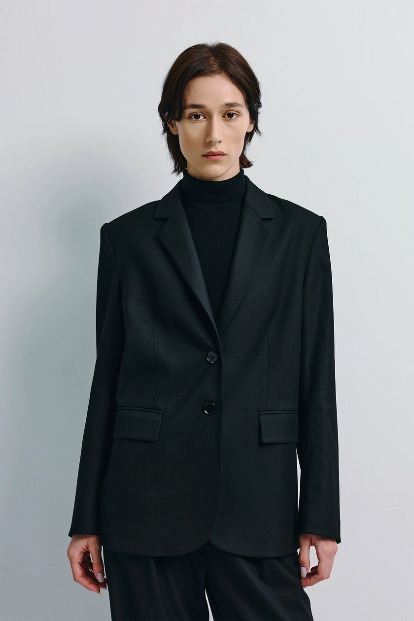 Black Neil Two-Button Blazer on model, tailored, single-breasted cut, everyday refinement.