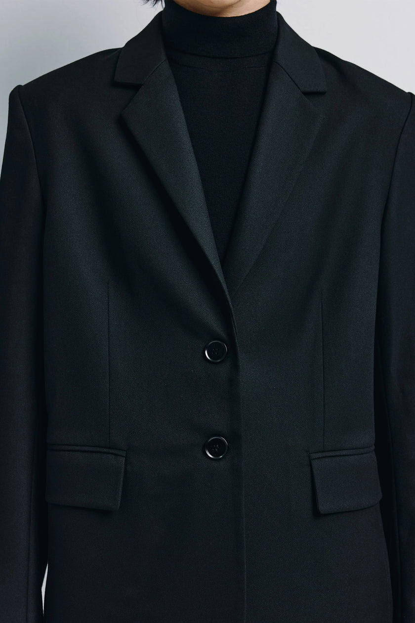 Black Neil Two-Button Blazer. Clean-lined tailored single-breasted cut, everyday refinement. Minimalist elegance.