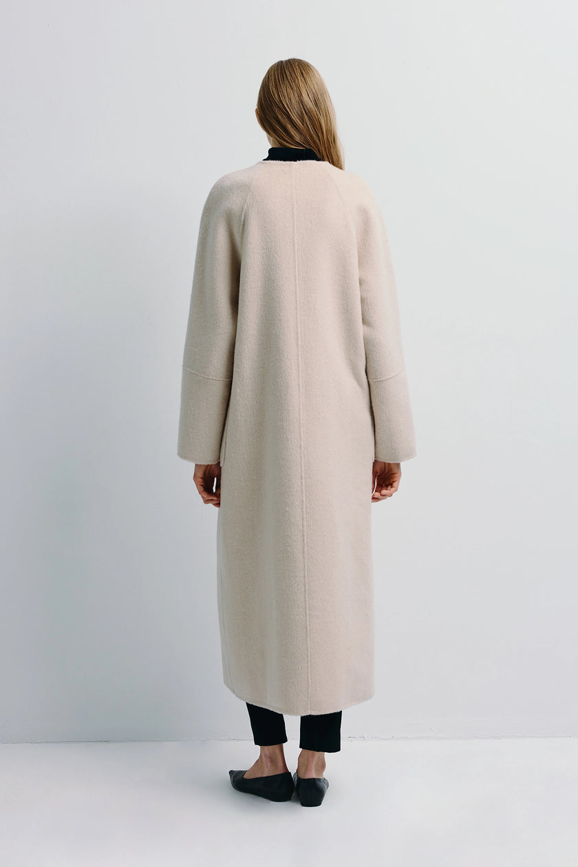 Back view of Iana Collarless Handmade Coat in light beige wool-alpaca blend. Featuring soft lines and a minimalist aesthetic.