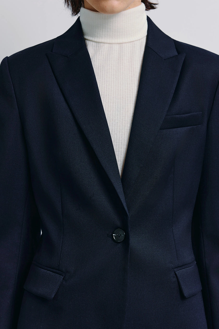 Navy Jin Slim Waist Wool Blazer with single-button closure, paired with a white turtleneck.